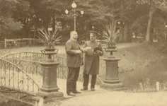 602792 Gezicht in het Park Tivoli te Utrecht, met op de brug portier G. van der Kreeft en een onbekende heer (Schouten?)